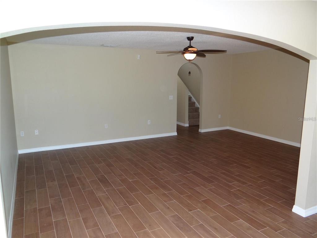 4654 Ashburn Square Drive Tampa, FL 33610 - Photo 4 of 11 a view of a hallway with wooden floor and a chandelier fan