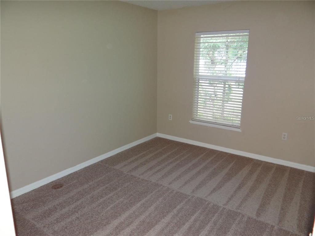 4654 Ashburn Square Drive Tampa, FL 33610 - Photo 7 of 11 an empty room with wooden floor and windows