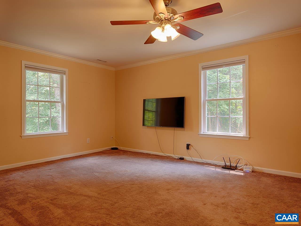 2115 Swift Run Road Ruckersville, VA 22968 - Photo 4 of 21 a view of an empty room with window a flat screen tv and fan