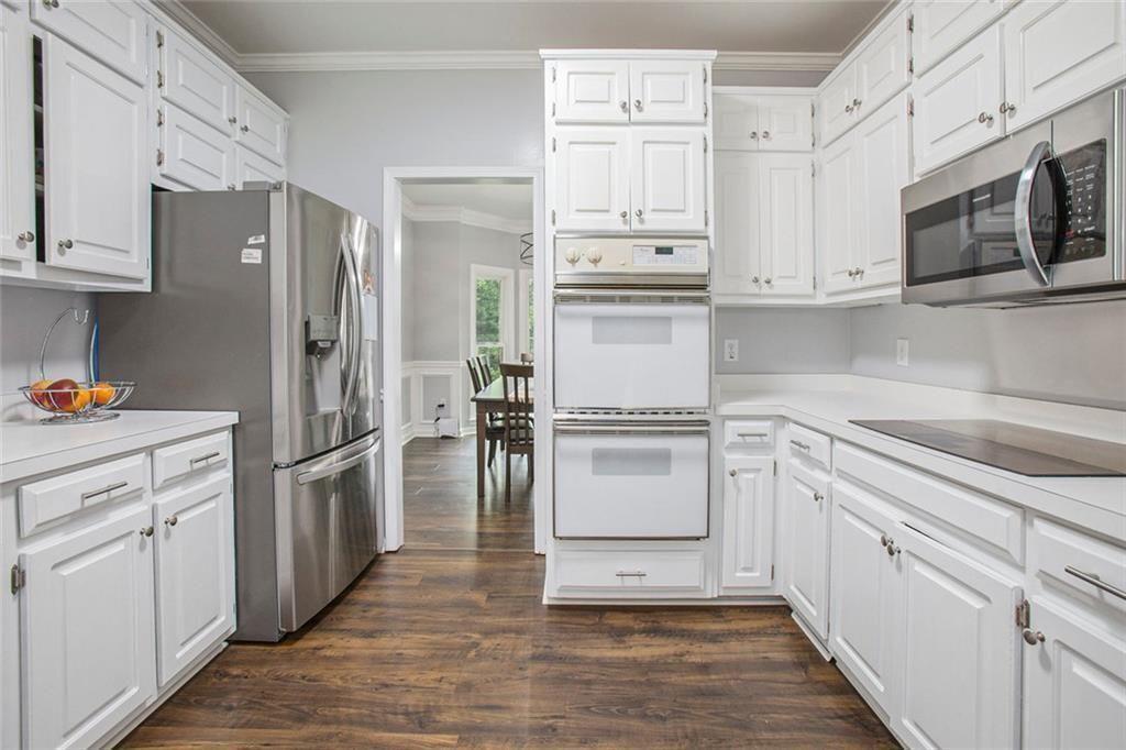 2482 Windchase Court Buford, GA 30518 - Photo 12 of 36 a kitchen with white cabinets and stainless steel appliances