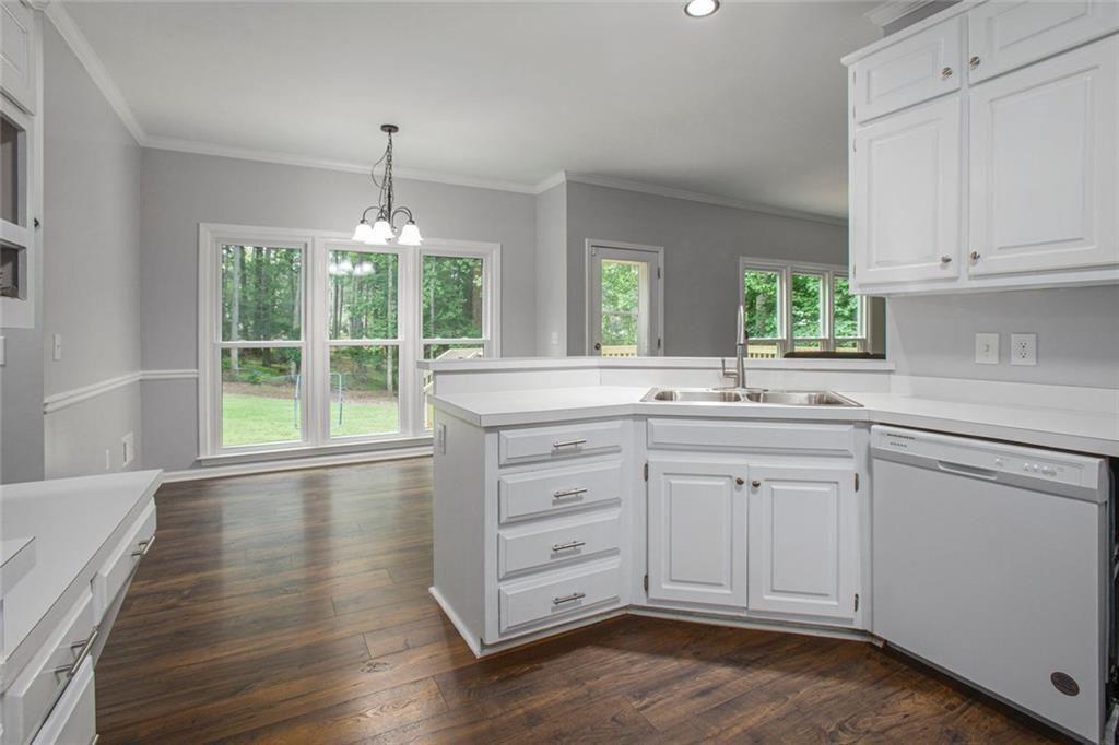 2482 Windchase Court Buford, GA 30518 - Photo 13 of 36 a kitchen with granite countertop white cabinets and a large window