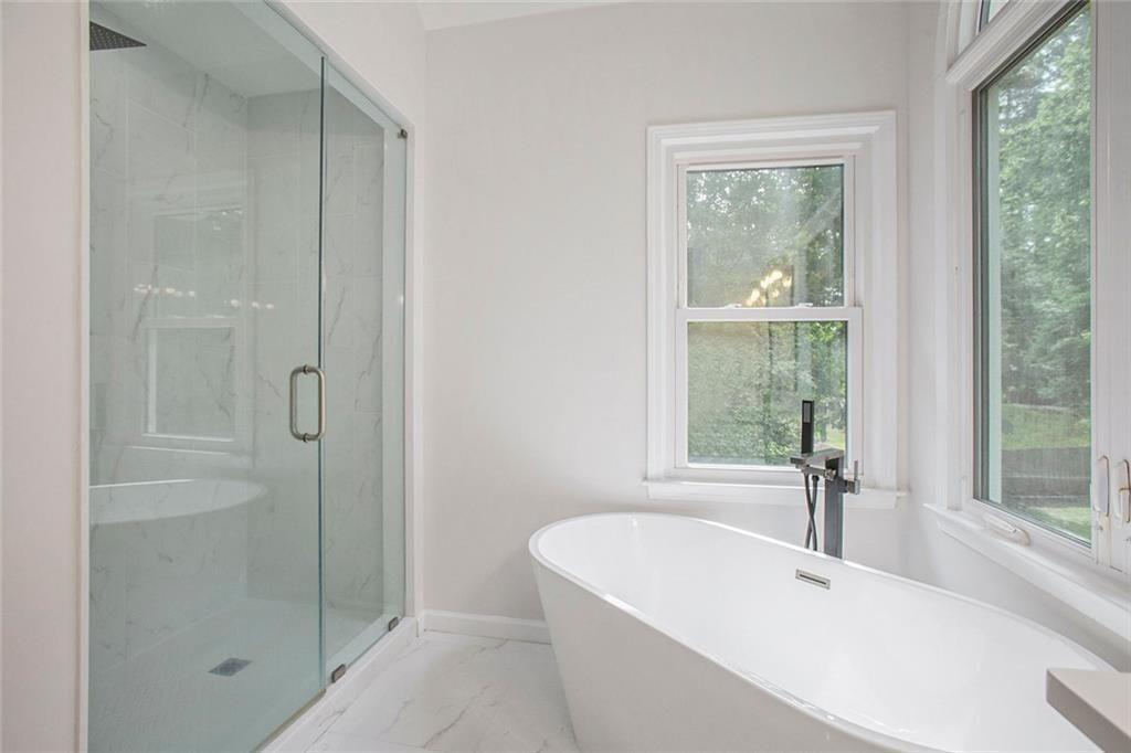 2482 Windchase Court Buford, GA 30518 - Photo 14 of 33 a bathroom with a bathtub and shower