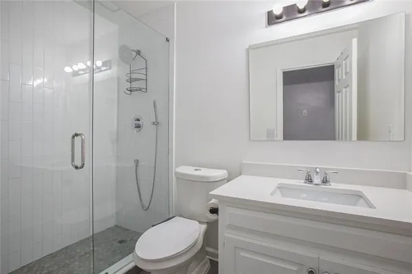 a bathroom with a toilet sink vanity and mirror