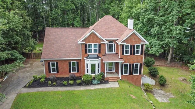 a aerial view of a house with yard and green space