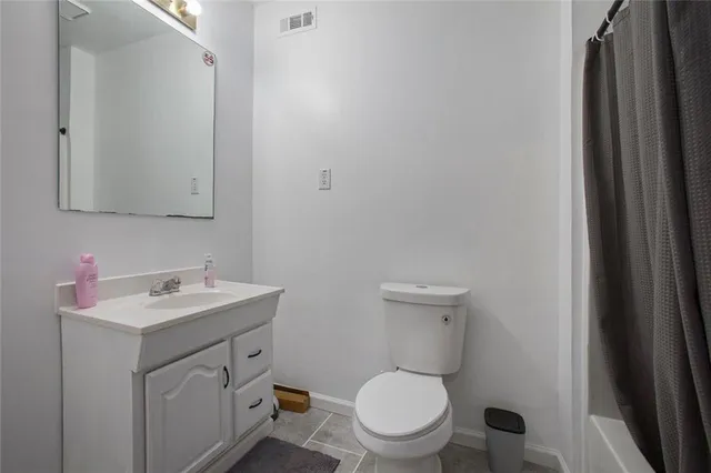 a bathroom with a toilet sink vanity and mirror