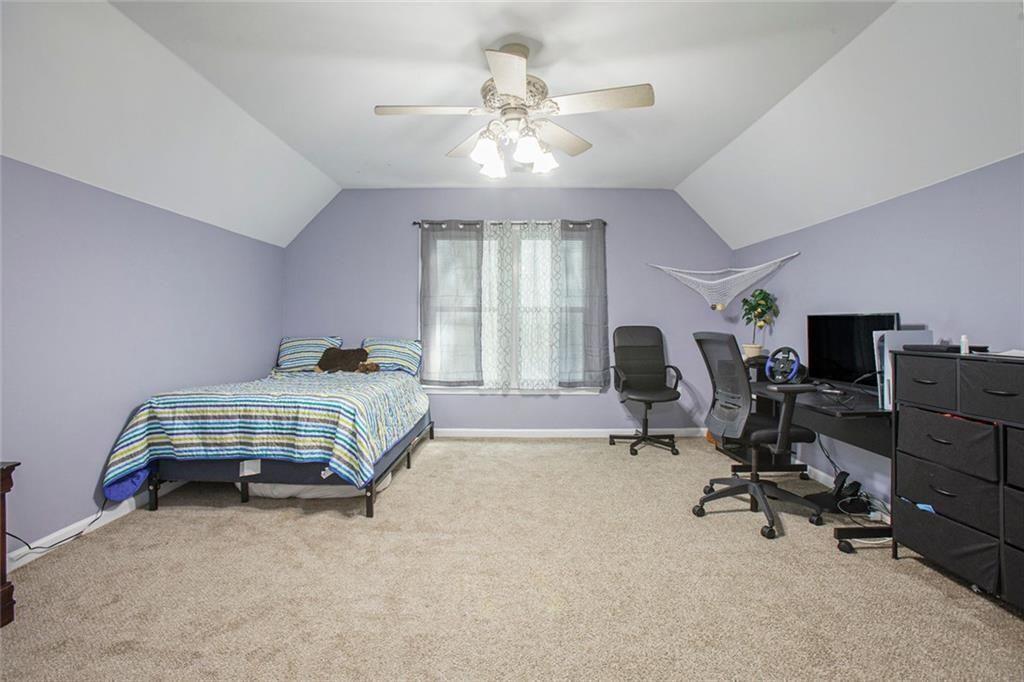 2482 Windchase Court Buford, GA 30518 - Photo 23 of 36 a bedroom with bed and a chandelier