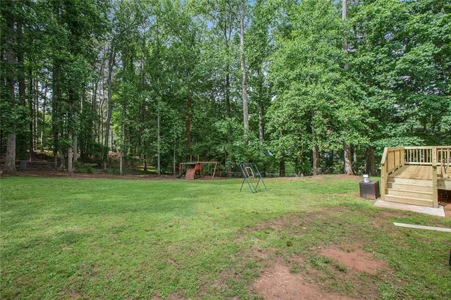 a backyard of a house with childrens swings and slides