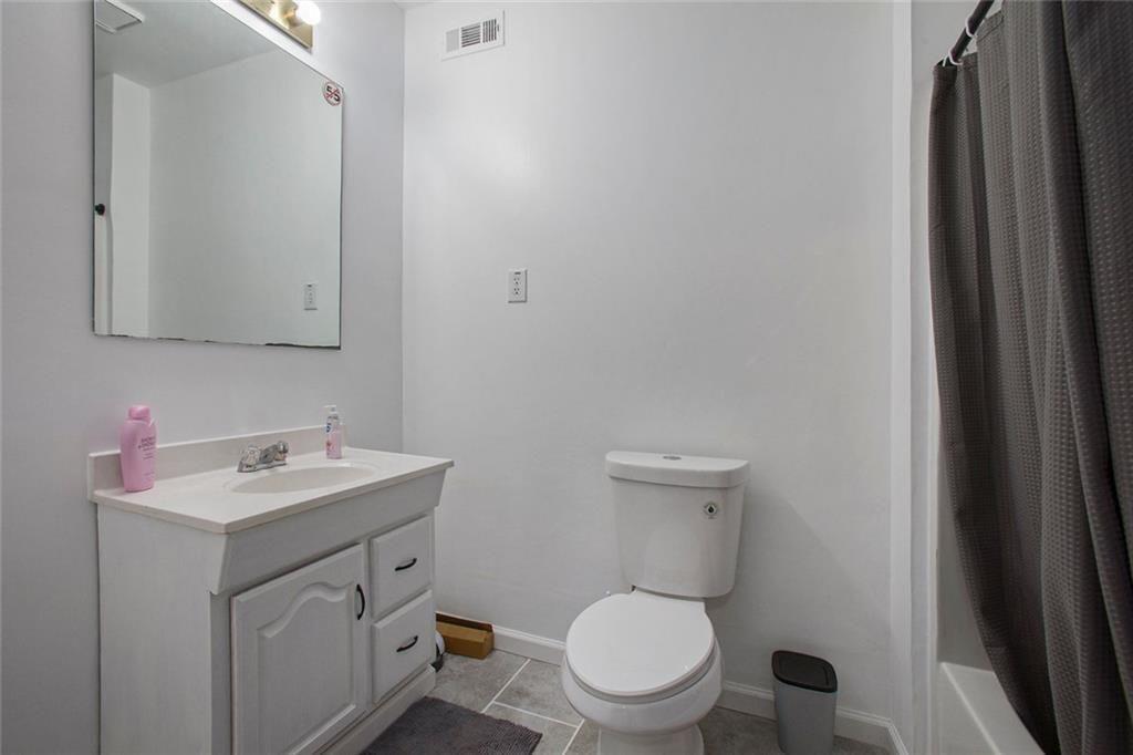 2482 Windchase Court Buford, GA 30518 - Photo 27 of 36 a bathroom with a toilet sink vanity and mirror