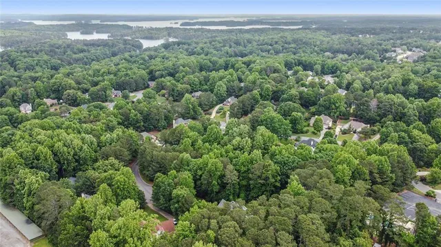an aerial view of residential houses with outdoor space and trees