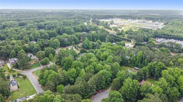 an aerial view of residential houses with outdoor space and trees