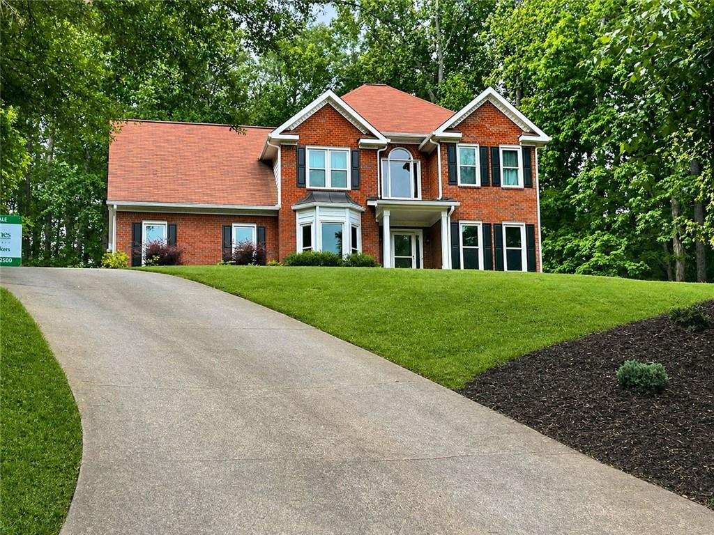 2482 Windchase Court Buford, GA 30518 - Photo 3 of 36 a front view of a house with a yard and trees