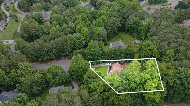 an aerial view of residential houses with outdoor space and trees