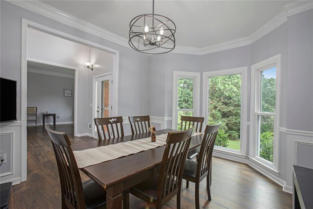 2482 Windchase Court Buford, GA 30518 - Photo 8 of 36 a view of a dining room with furniture a chandelier and wooden floor