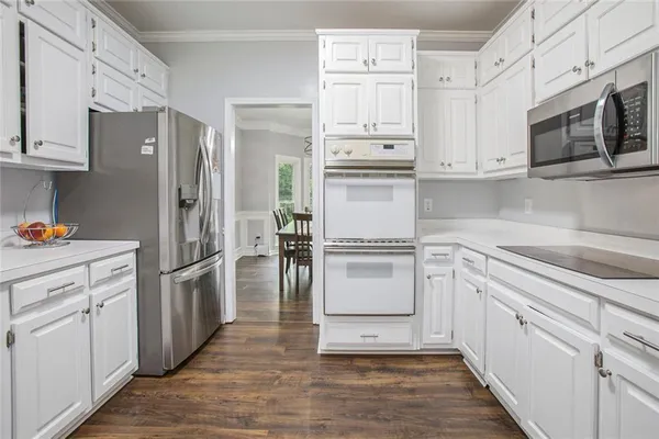 a kitchen with granite countertop white cabinets and a large window