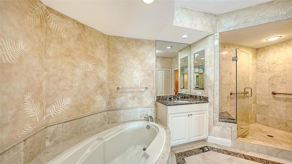401 North Point Road, Unit 301 Osprey, FL 34229 - Photo 27 of 91 a bathroom with a granite countertop sink a mirror a bathtub and shower