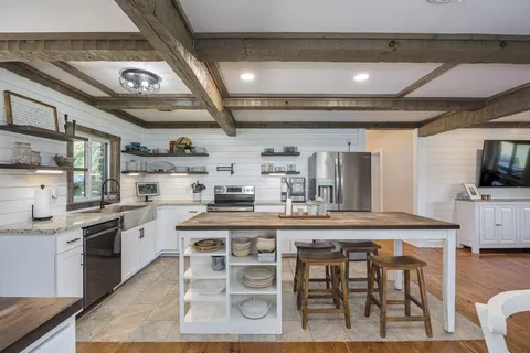 a bathroom with a granite countertop sink a toilet and shower