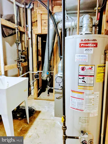 a utility room with multiple dryer washer and a view of living area