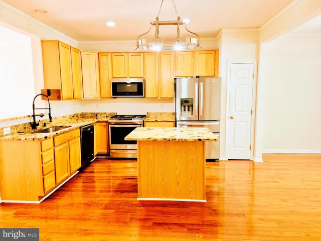 a kitchen with stainless steel appliances granite countertop a sink a stove top oven a counter space and cabinets