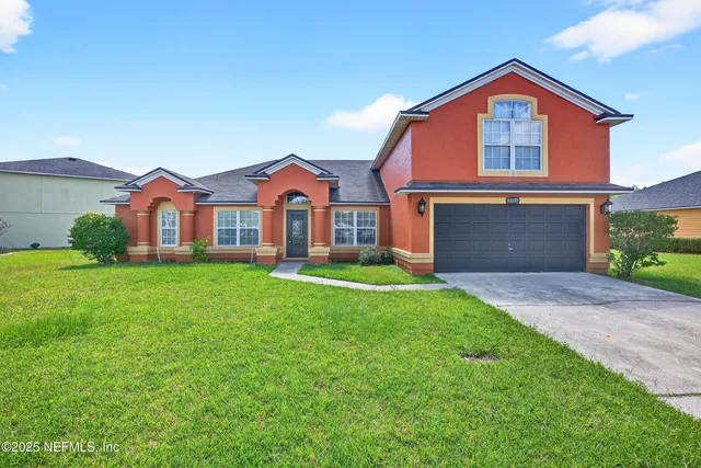 a front view of a house with yard and garage
