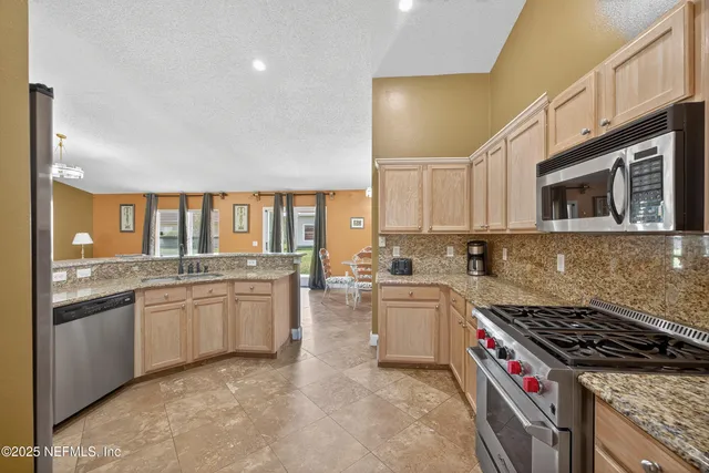 a large kitchen with a large counter top space and stainless steel appliances