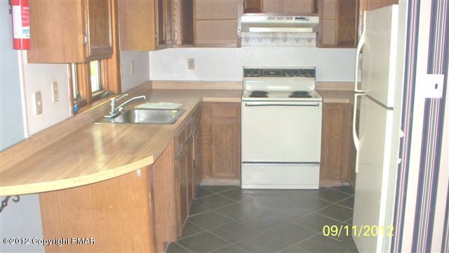 7036 Bull Road Long Pond, PA 18334 - Photo 4 of 7 a kitchen with a sink stove and refrigerator