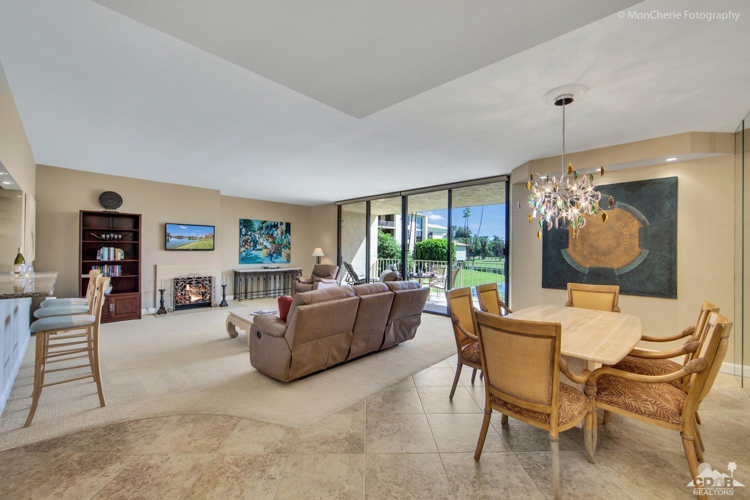 910 Island Drive, Unit 211 Rancho Mirage, CA 92270 - Photo 2 of 38 a living room with fireplace furniture and a large window