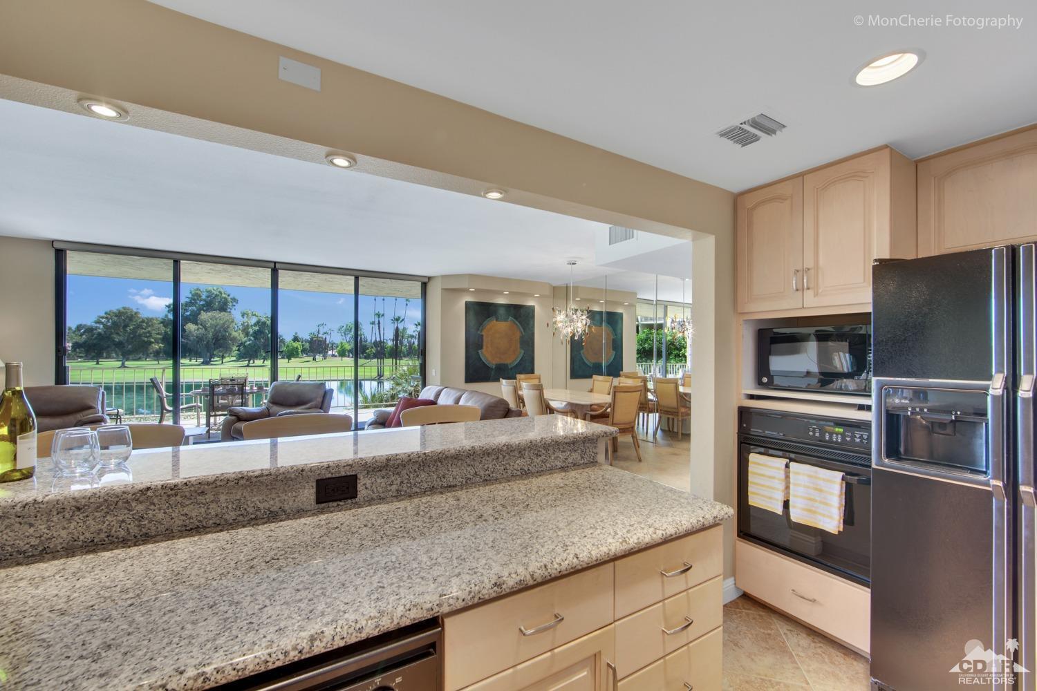 910 Island Drive, Unit 211 Rancho Mirage, CA 92270 - Photo 12 of 38 a kitchen with granite countertop lots of counter top space dining table and stainless steel appliances