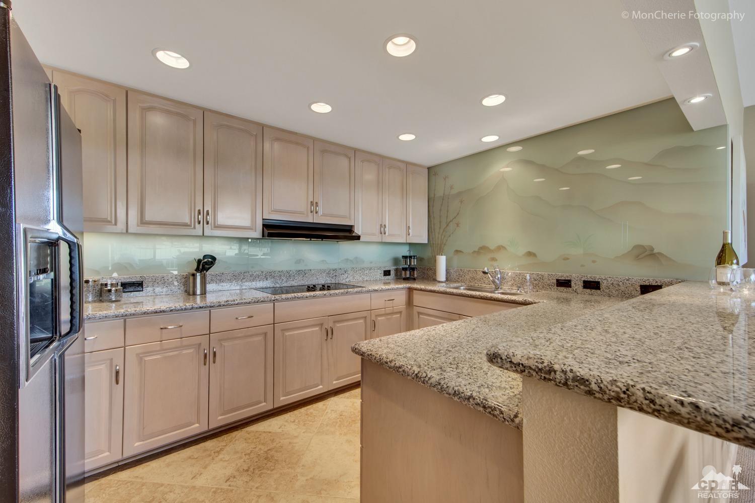 910 Island Drive, Unit 211 Rancho Mirage, CA 92270 - Photo 13 of 38 a kitchen with granite countertop a sink and cabinets