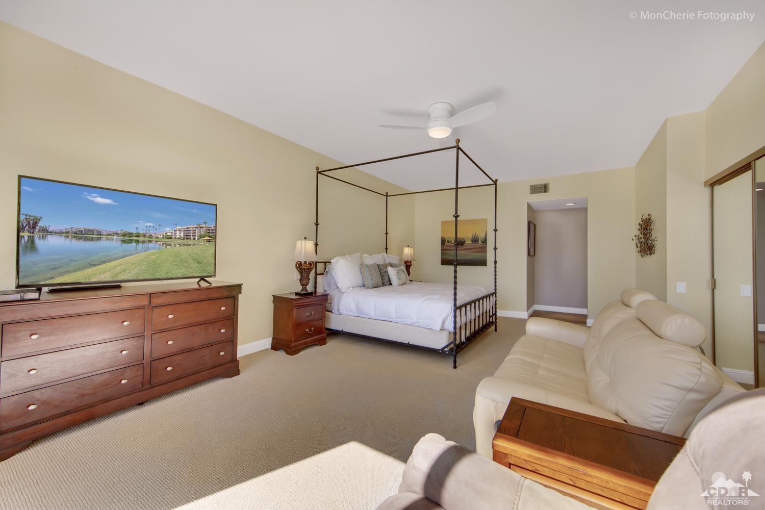 910 Island Drive, Unit 211 Rancho Mirage, CA 92270 - Photo 21 of 38 a bedroom with a bed and a flat screen tv