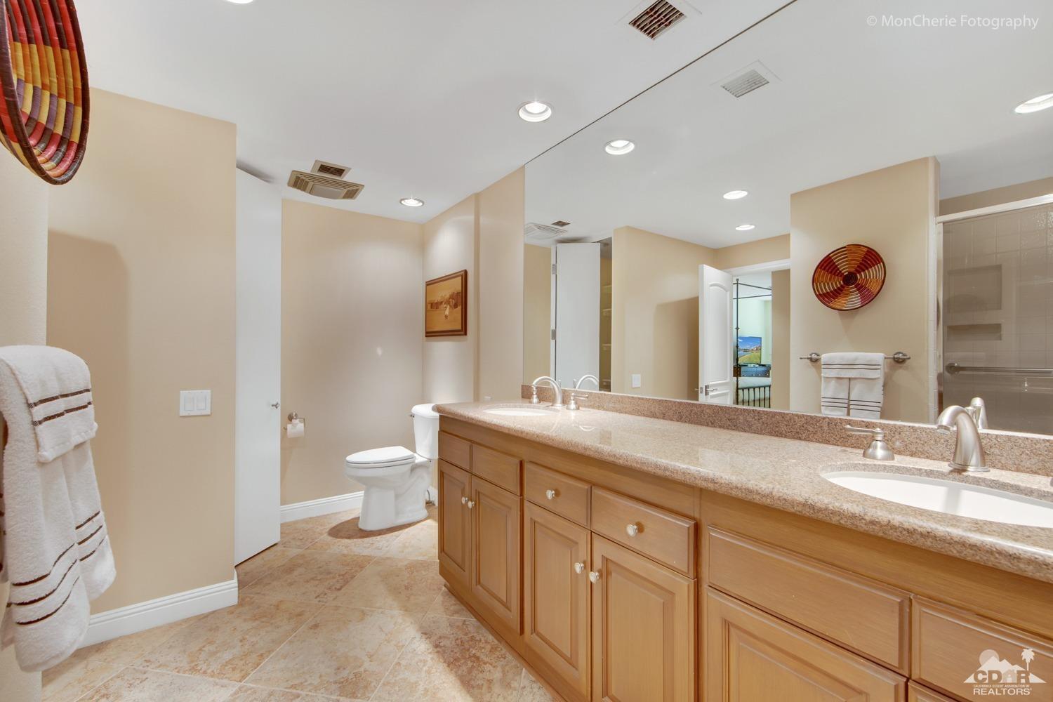 910 Island Drive, Unit 211 Rancho Mirage, CA 92270 - Photo 22 of 38 a spacious bathroom with a granite countertop sink mirror and toilet