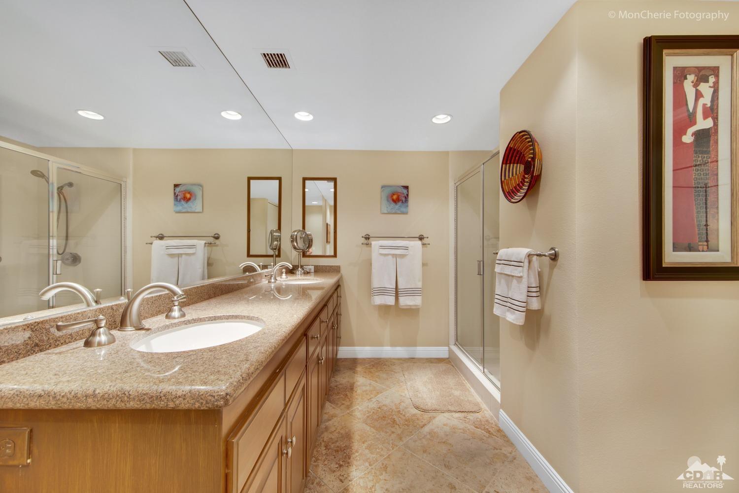 910 Island Drive, Unit 211 Rancho Mirage, CA 92270 - Photo 23 of 38 a bathroom with a granite countertop sink a mirror and a shower