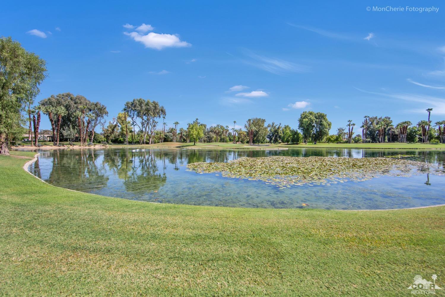 910 Island Drive, Unit 211 Rancho Mirage, CA 92270 - Photo 30 of 38 a view of a lake with houses in the background
