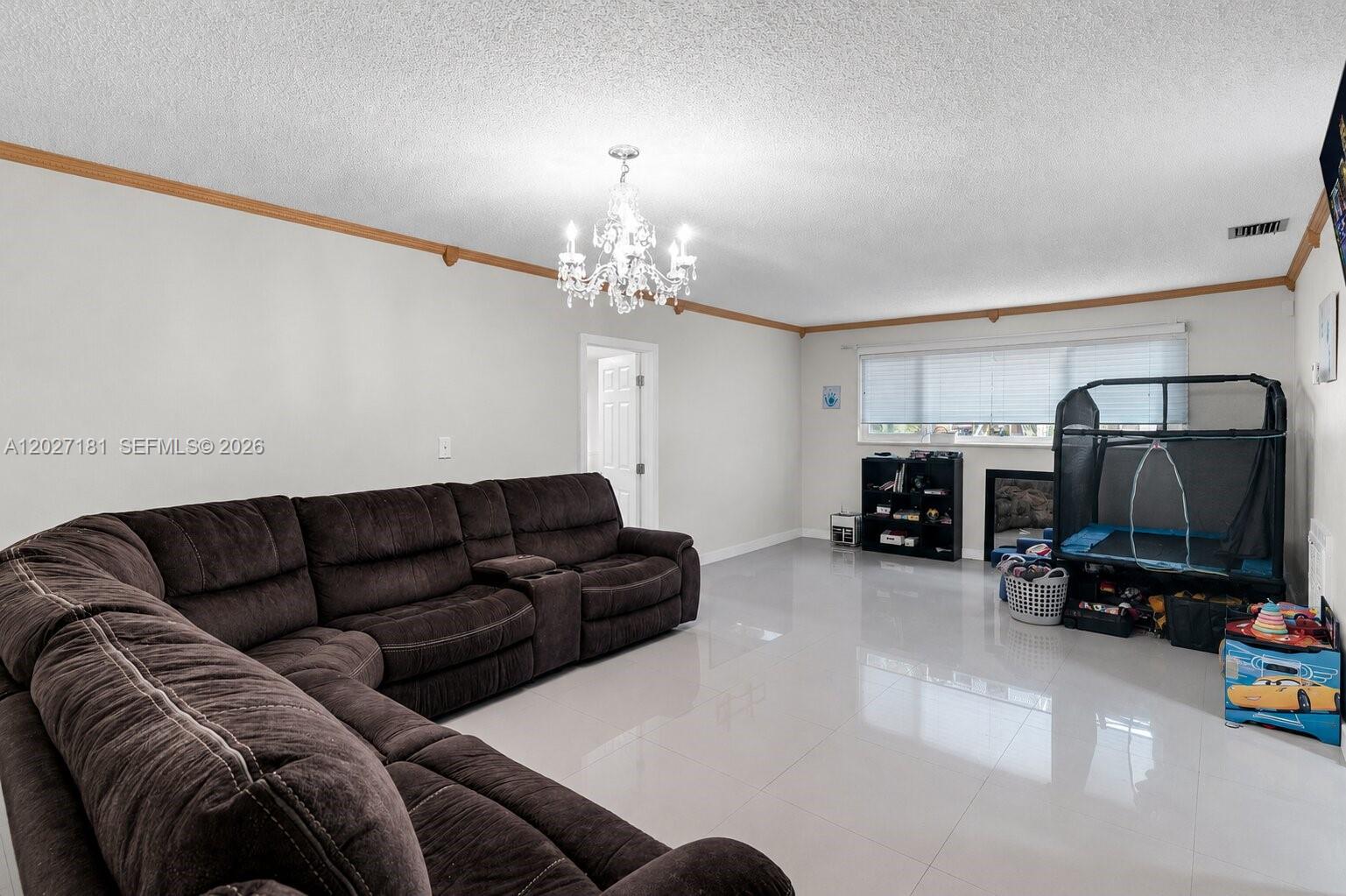 15440 Southwest 294th Terrace Homestead, FL 33033 - Photo 7 of 31 a living room with furniture and a chandelier