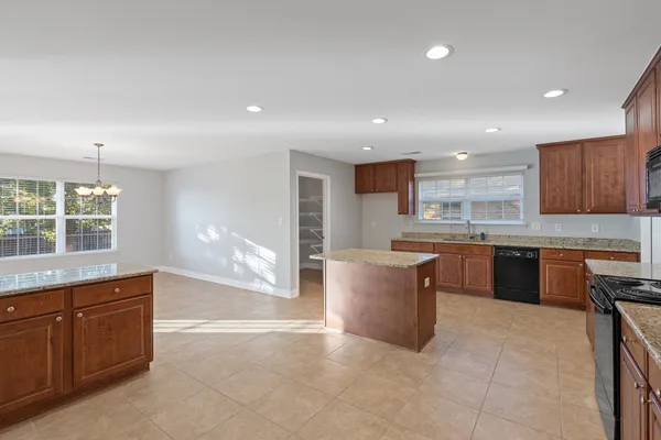 a large kitchen with a large counter top and stainless steel appliances