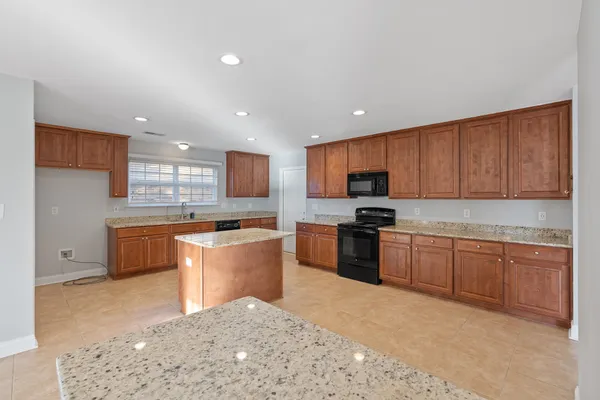 a kitchen with stainless steel appliances granite countertop a stove a sink dishwasher a refrigerator and a oven with granite countertops