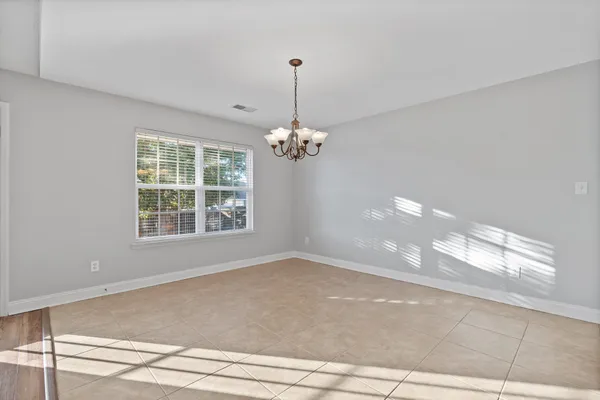 a view of wooden floor chandelier and window in a room