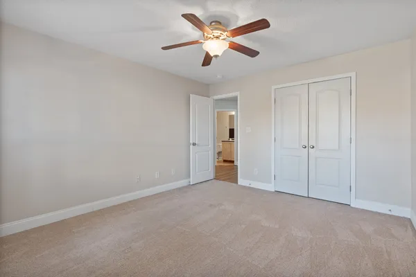 a view of an empty room and a ceiling fan