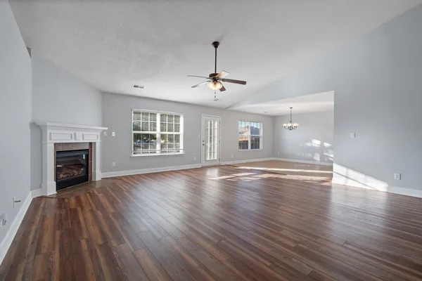 a view of empty room with wooden floor and fireplace