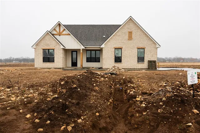a front view of house with yard and trees in the background