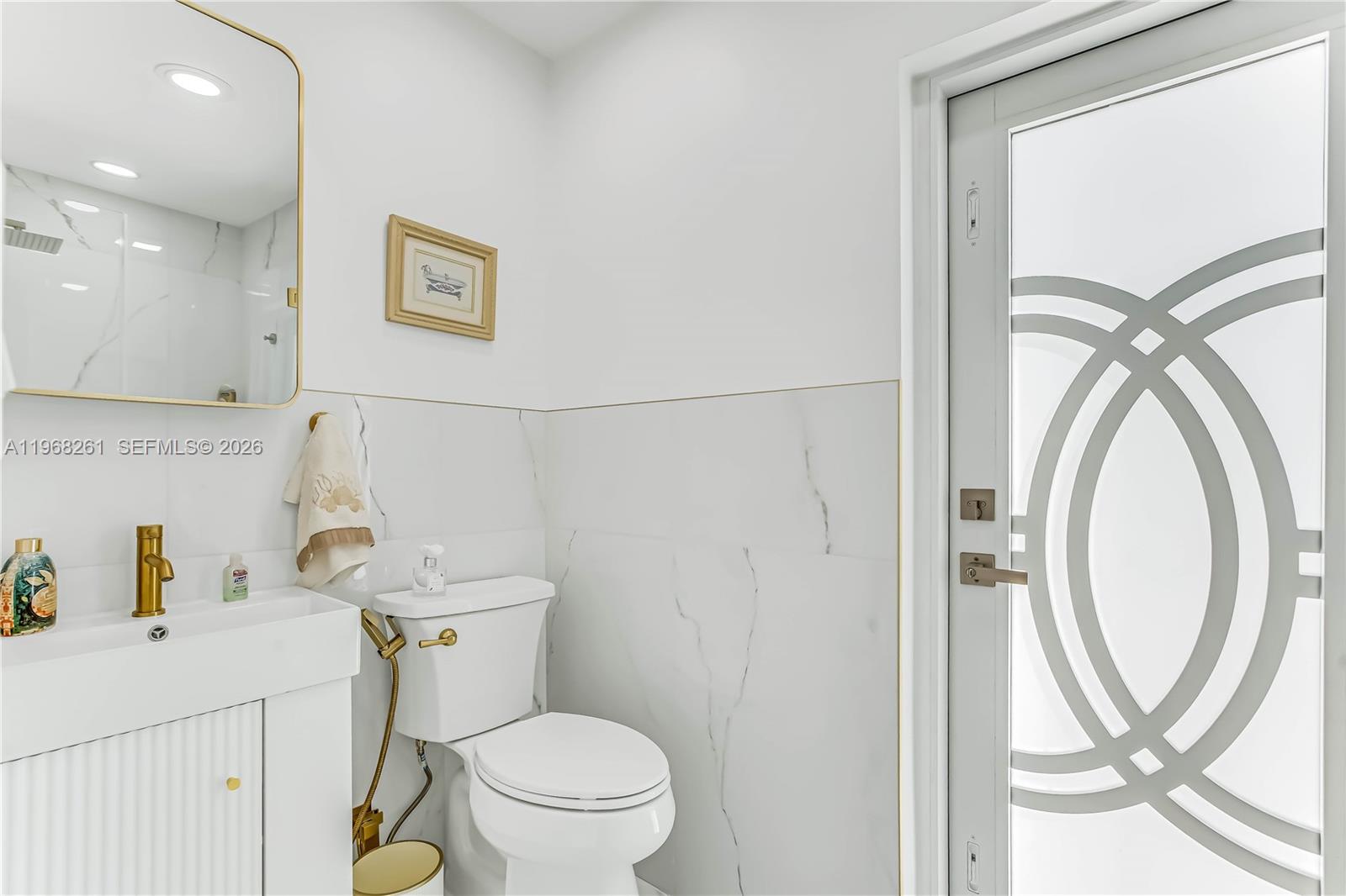 500 94th Street Surfside, FL 33154 - Photo 43 of 47 a bathroom with a sink a toilet and a mirror