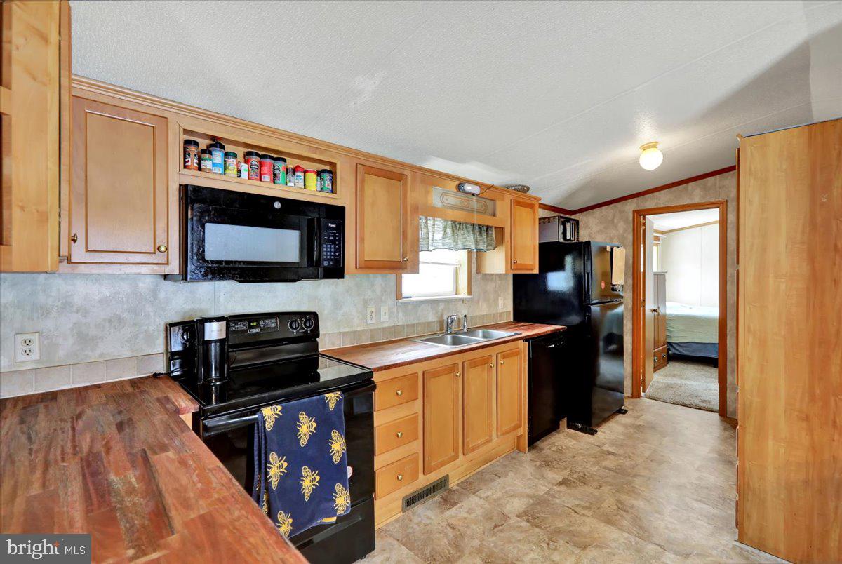 125 Tuckerton Road, Unit 916 Reading, PA 19605 - Photo 9 of 19 a kitchen with stainless steel appliances granite countertop a stove top oven a sink dishwasher a refrigerator and a microwave oven with wooden floor