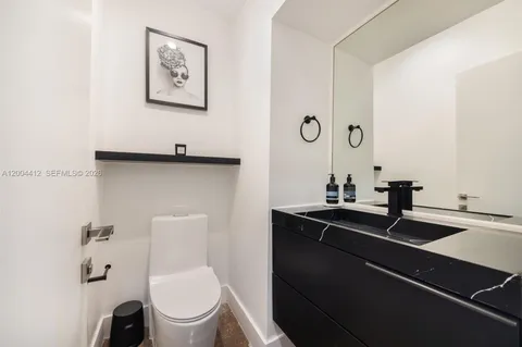 a bathroom with a toilet a sink and mirror