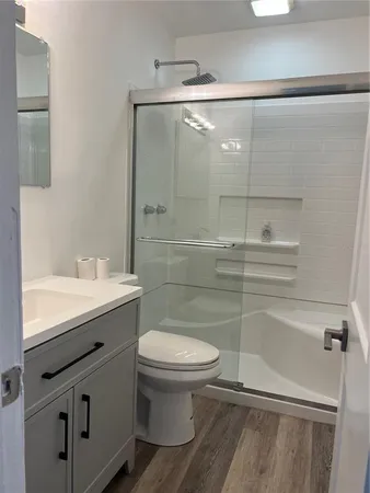 a bathroom with a sink a toilet and shower