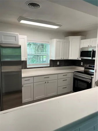 a kitchen with granite countertop a stove a sink and a microwave