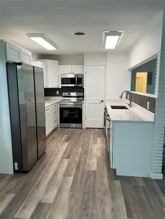 a kitchen with stainless steel appliances granite countertop a refrigerator and a stove top oven