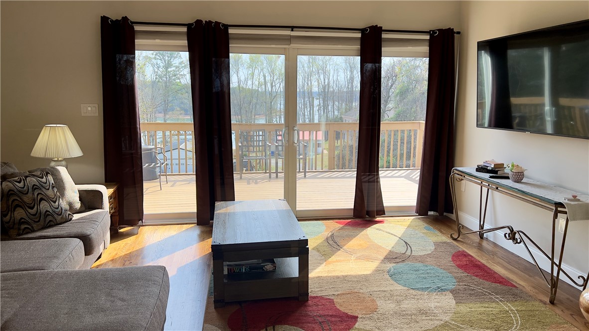 160 Hudgins Lake Road Townville, SC 29689 - Photo 28 of 41 Natural light streams through sliding glass doors, illuminating the inviting living area and hardwood floors.