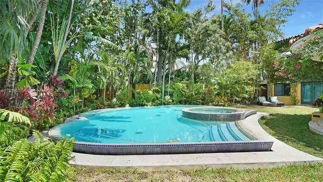 a spacious bedroom with a large bed and a chandelier