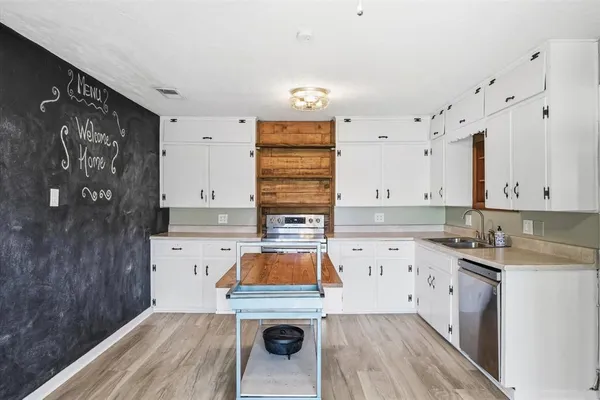 a kitchen with a table chairs stove and cabinets