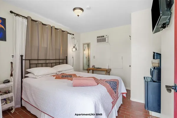 a bedroom with a bed and a flat screen tv