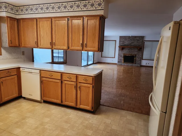 a view of an empty room with a fireplace and a window